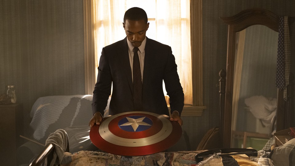 Sam Wilson (played by Anthony Mackie) looks down at Captain America's shield in his hands