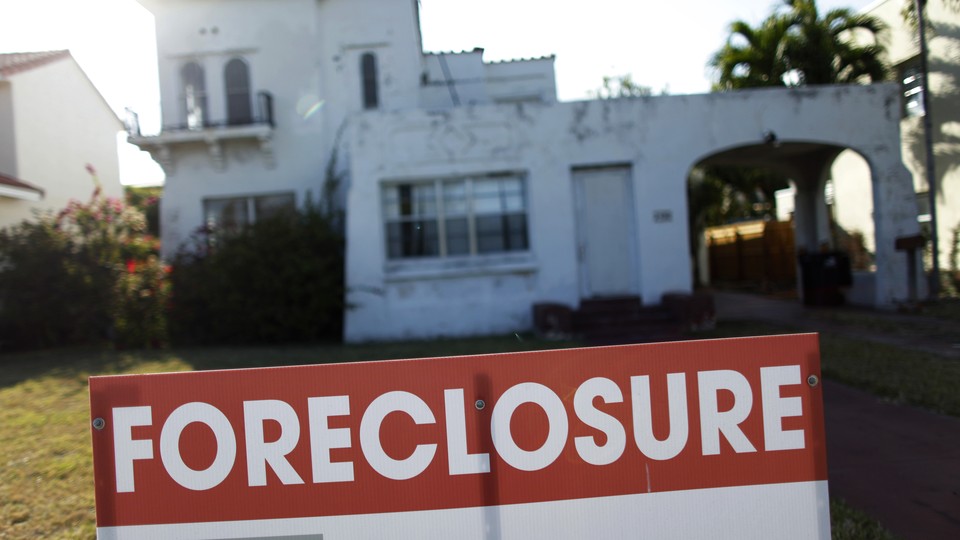 A foreclosure sale sign sits in front of a house in Miami Beach.