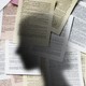 A shadow of a woman against a wall of legal papers