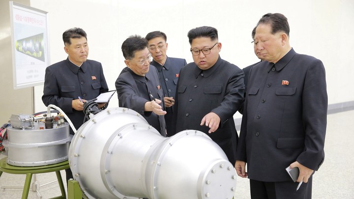 Kim Jong Un and North Korean officials examine what appears to be a missile