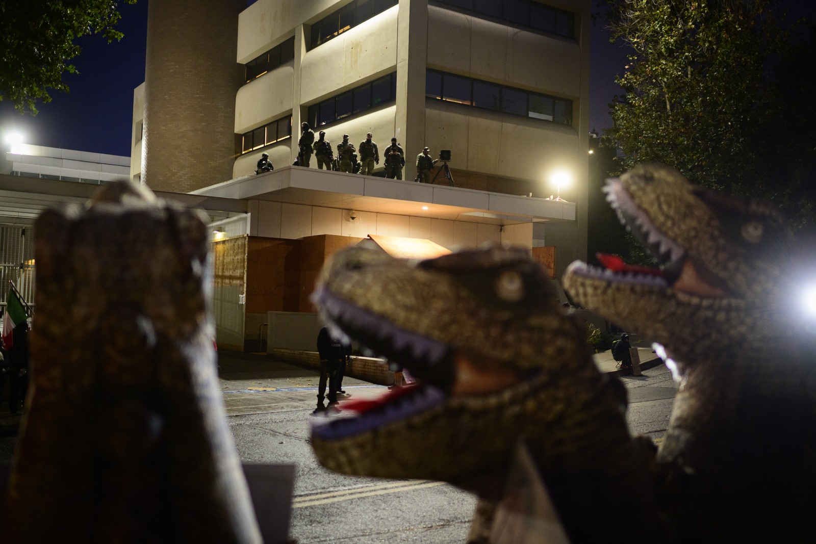 Anti-I.C.E. protesters in dinosaur costumes dance outside of the U.S. Immigration and Customs Enforcement building in Portland.
