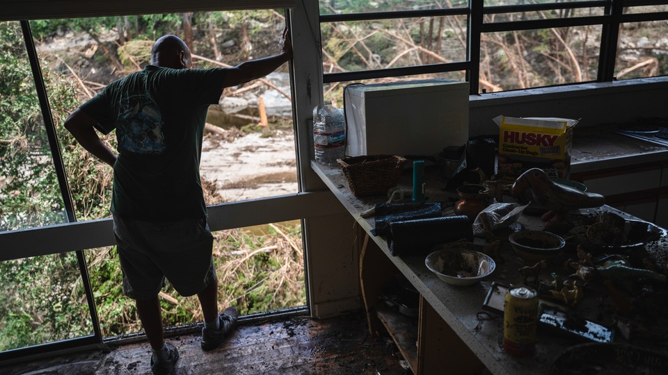 A volunteer looks out over the Guadalupe River while helping clean a resident's home in Hunt, Texas.