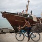 Children playing on the rusting remains of a wrecked ship which was lifted and smashed onto the town's sea wall during a king tide in February 2015.