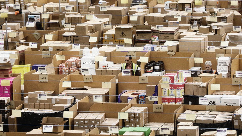 A man sitting at a cubicle among many boxes