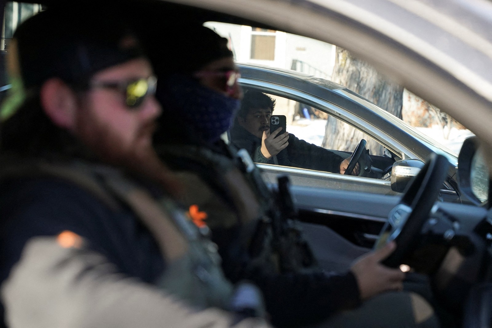A person in a car takes video of federal agents driving in another car.