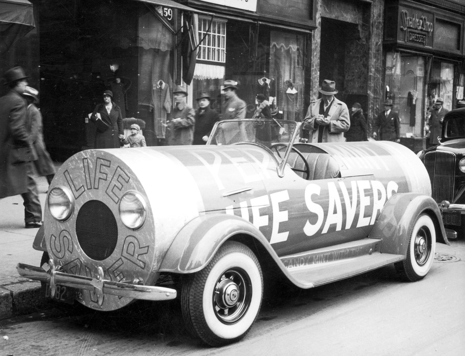A car, designed to resemble a Life Savers candy roll, sits parked at a curb.