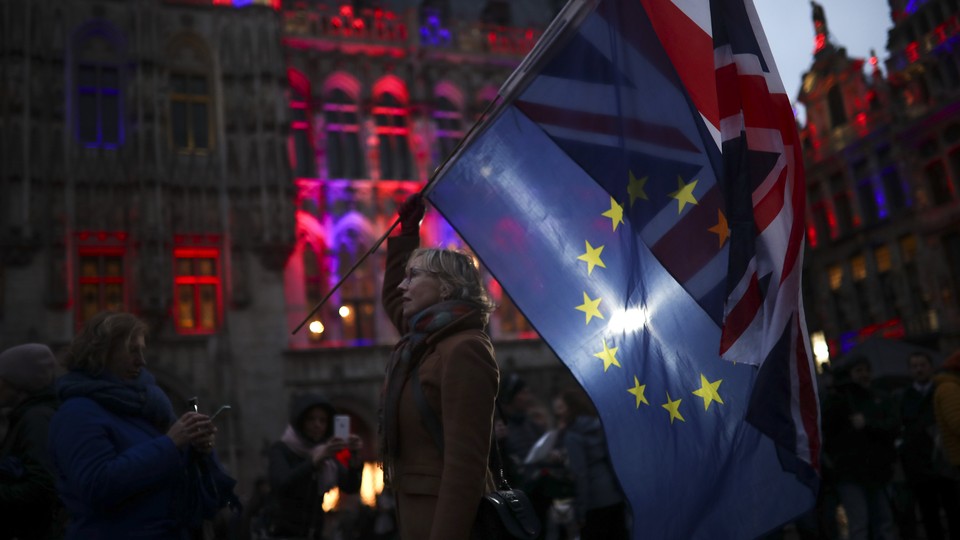 A woman holding the European Union and Union Jack flags.