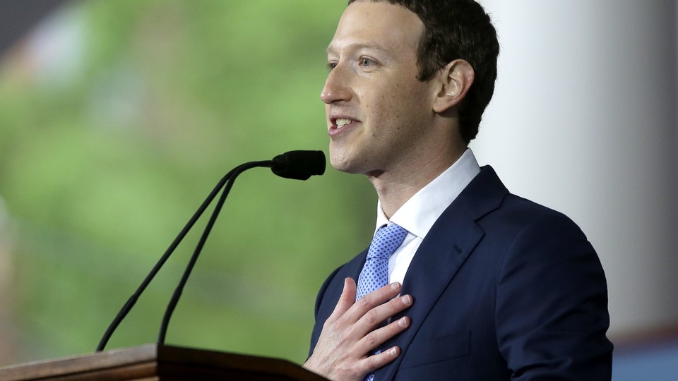 Mark Zuckerberg speaks at a podium with a hand over his heart.