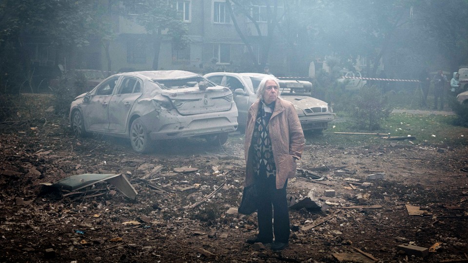 A Ukrainian woman surveys damage caused by a Russian missile in Zaporizhzhya.