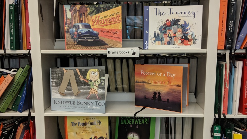 A shelf holds children's books in braille