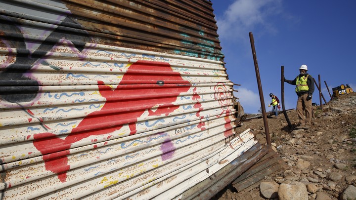 A crew removes part of a border wall near Tijuana, Mexico.