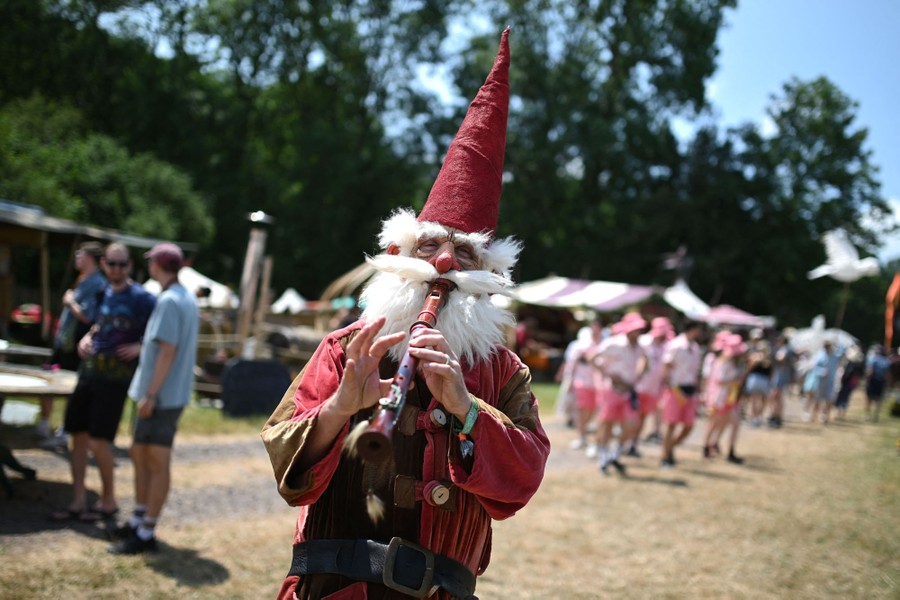 A person wearing a gnome costume plays an instrument.