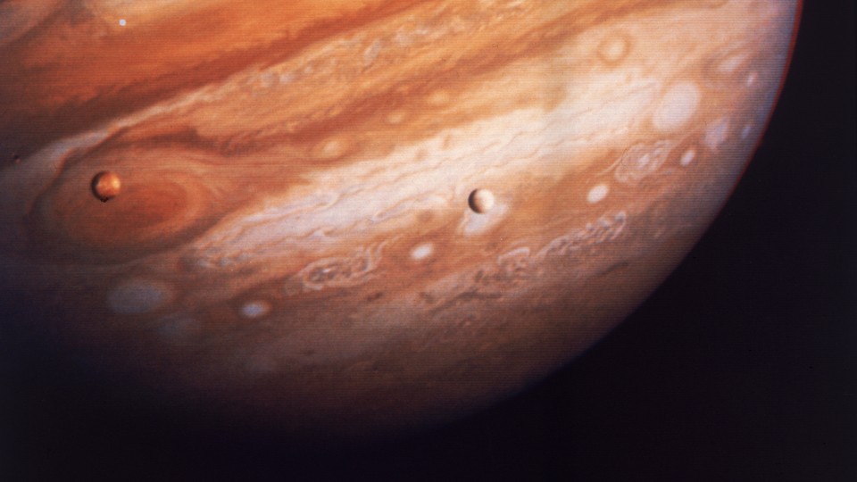 Jupiter and two of its moons, Io (left) and Europa (right)