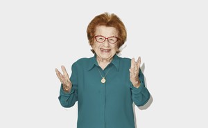 A photo of Dr. Ruth holding out her hands and smiling