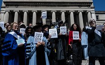 Photograph of a faculty protest at Columbia University in April, with professors holding up signs that say "Hands off our students"