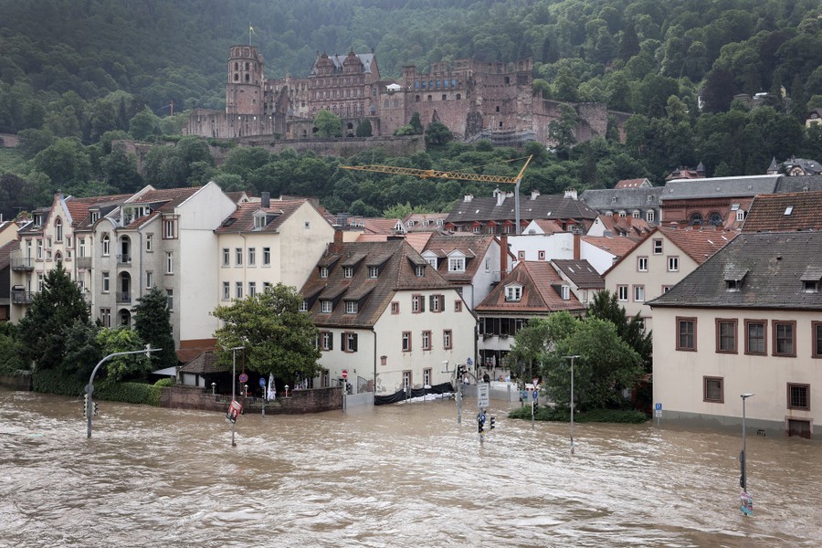 A castle sits on a hillside above the historic part of a German city, which is being flooded by a swollen river.