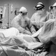 Doctors wearing PPE surrounding a coronavirus patient.