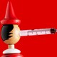 A Pinocchio figure with a vaccine syringe for a nose