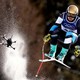 A skier, followed closely by a camera drone, catches some air during a downhill race.