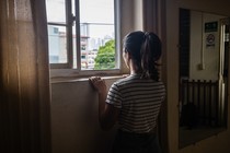 A woman looks out a window