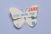 A paper cutout of a calendar in the shape of a butterfly