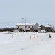 A man on a four-wheeler in a snowy backdrop heads downriver into Bethel.