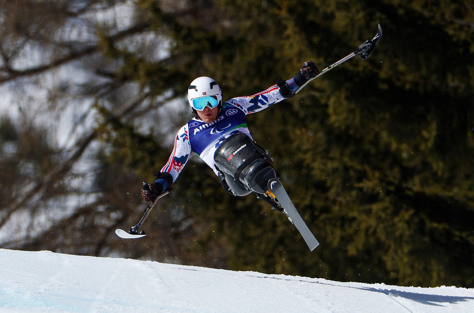 A seated skier catches some air during a fast downhill run, their arms outstretched.