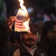 An Iranian protester burns the U.S. flag