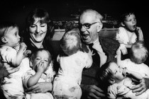 Dr. Spock smiling at many babies