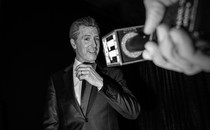 Black-and-white photo of Gavin Newsom in front of a mic held out by a hand