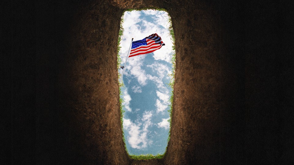 An American flag is viewed against the sky, from inside a freshly dug grave