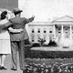 A black and white photograph collage of a couple in modest suits. The man is gesturing toward the White House.