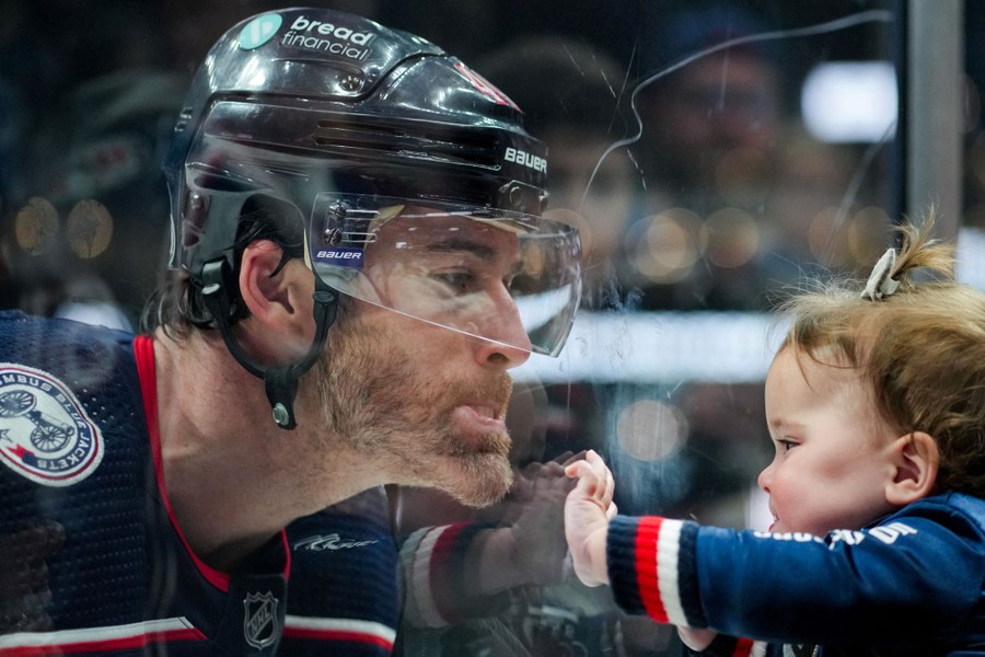 A hockey player makes faces with his young daughter.