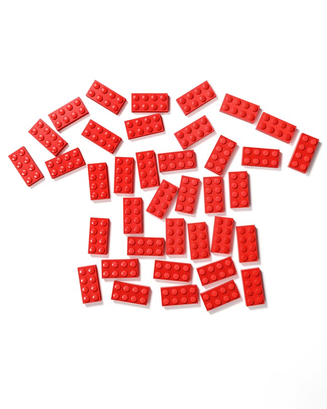 illustration of red lego bricks arranged in the shape of a child's T-shirt on white background