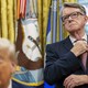 Photograph of British ex-ambassador standing behind Donald Trump