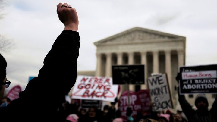 Competing demonstrators displaying anti-abortion and pro-abortion-rights signs at the annual March for Life