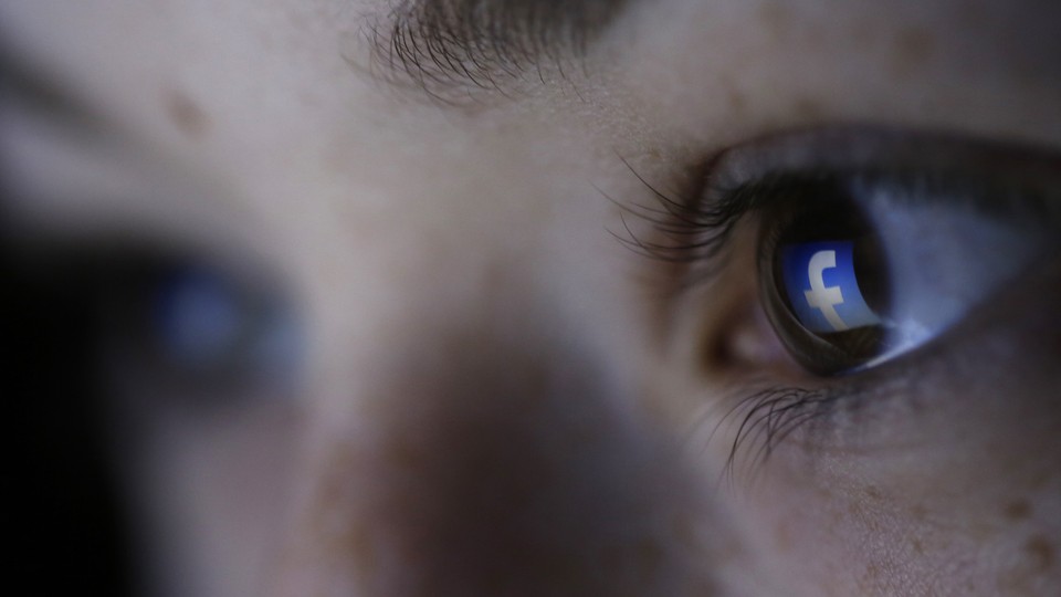 The Facebook logo reflected in a person's pupil