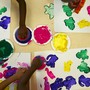 Children use stamps dipped in paint to make art.