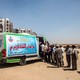 Egyptian workers line up near a van for an examination check-up for Hepatitis C