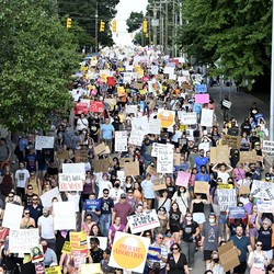 Hundreds of pro-abortion-rights demonstrators march in a street.