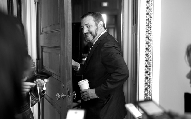 Ted Cruz walking through a door, away from throng of reporters