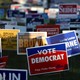 Dozens of colorful campaign signs are posted in the grass outside of a polling station on the last day of early voting in Dallas, Texas, before the 2018 midterm election.
