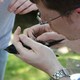 A man holds and examines a purple martin.
