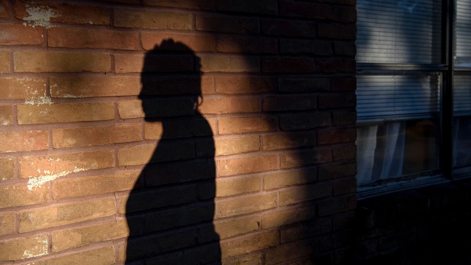 A woman's silhouette on a brick wall