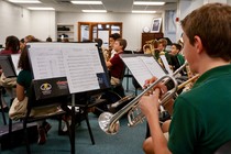 Students play band instruments including trumpets, tubas, and French horns.