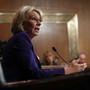 Betsy DeVos sits at a microphone during her hearing.