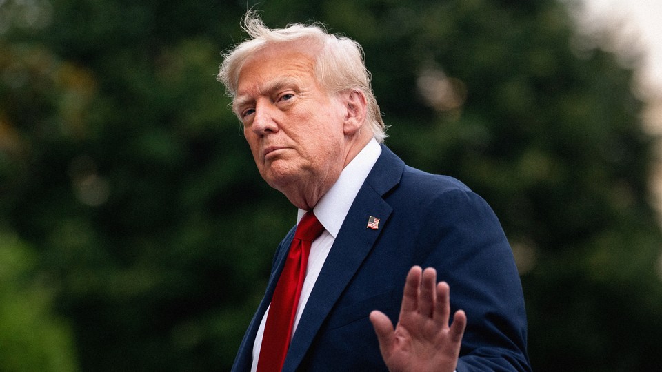 Donald Trump holds up his hand as he walks away