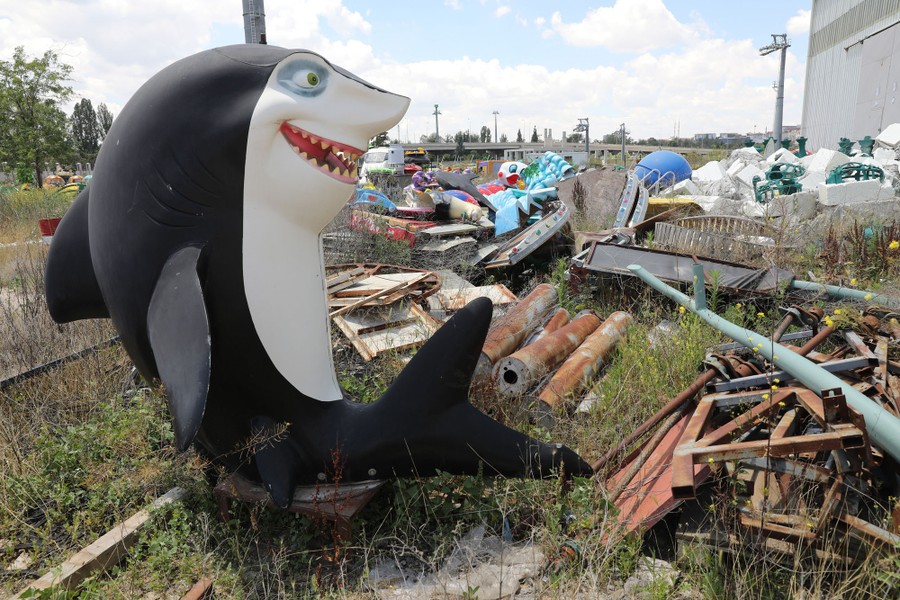 Abandoned amusement-park materials sit in a field.