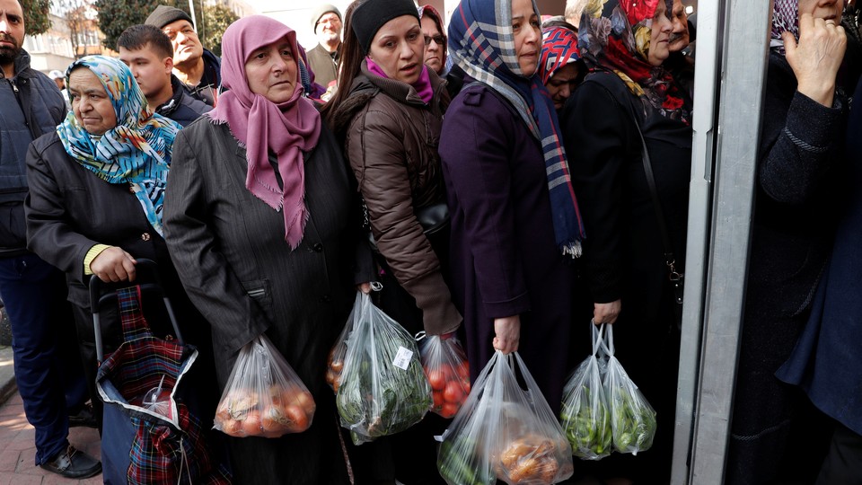 People wait in line to buy vegetables at a tent set up in Istanbul by the municipality.