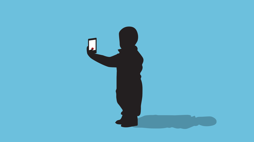 A small child takes a selfie on a smartphone.